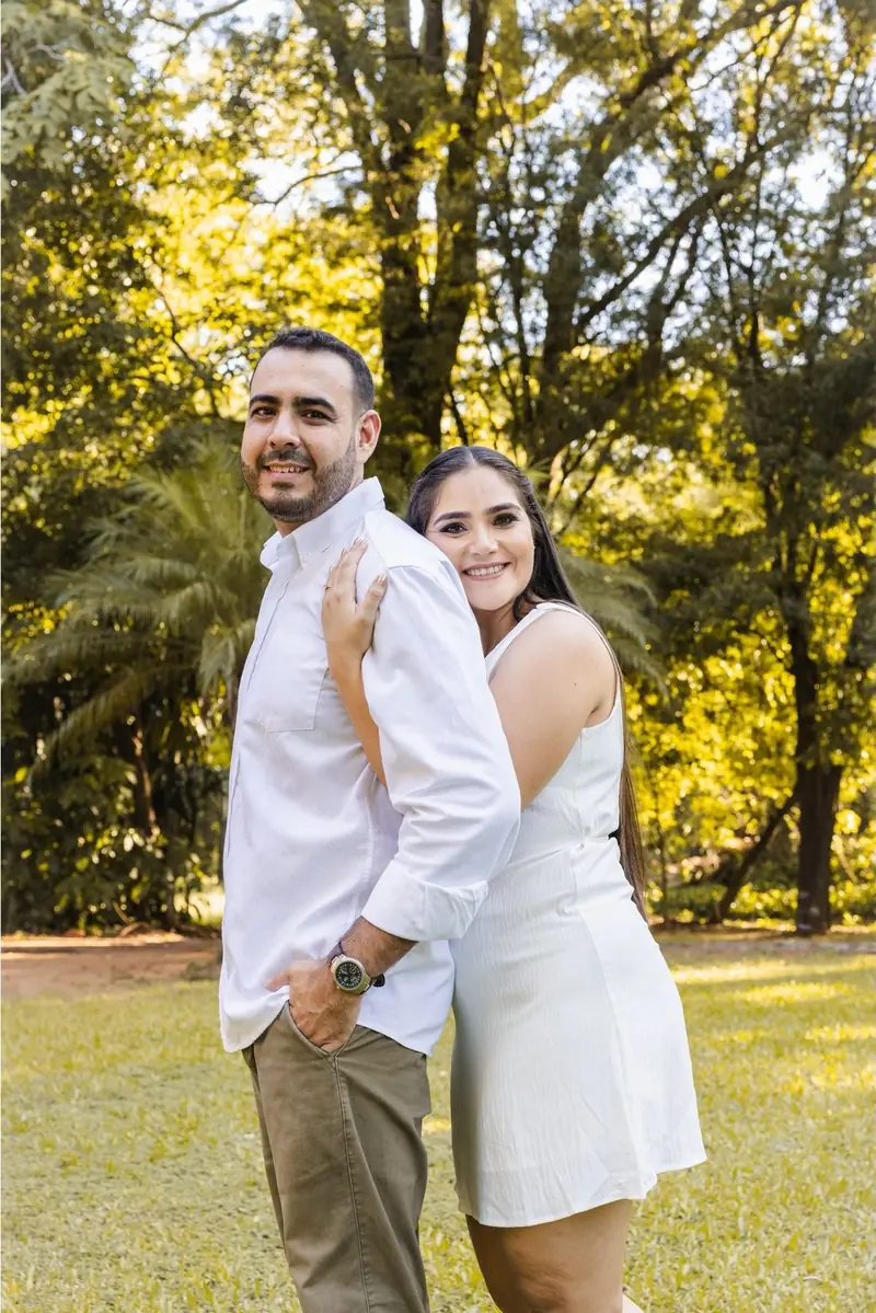 Pareja a punto de besarse junto a un árbol