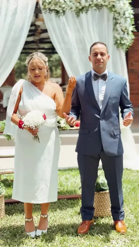 Novios de la mano frente al altar al aire libre