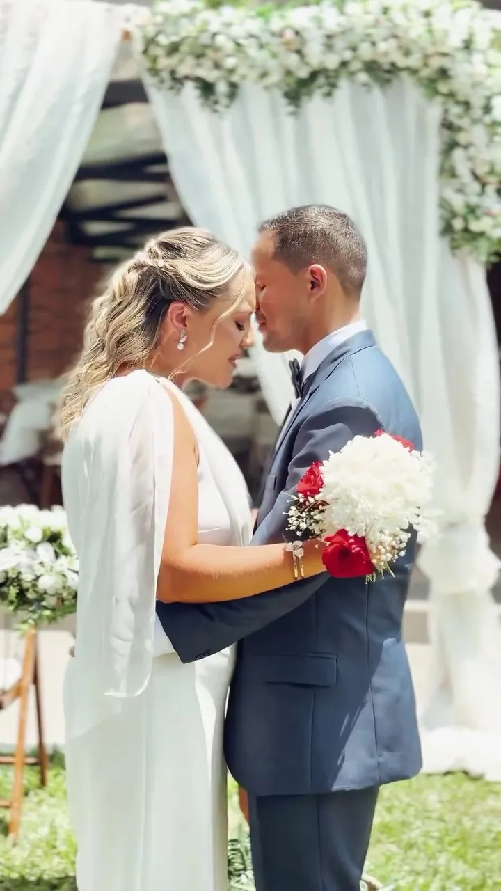 Novios abrazados con el ramo después de la ceremonia