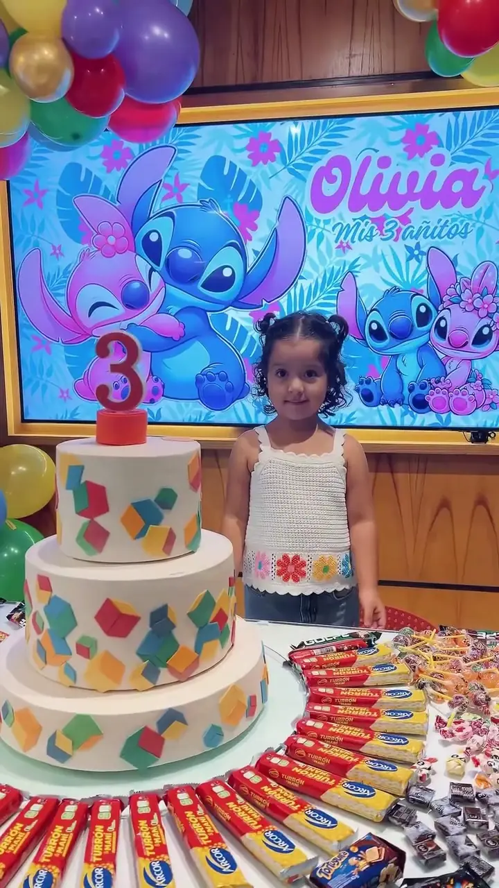 Niña con su torta de cumpleaños de tres pisos