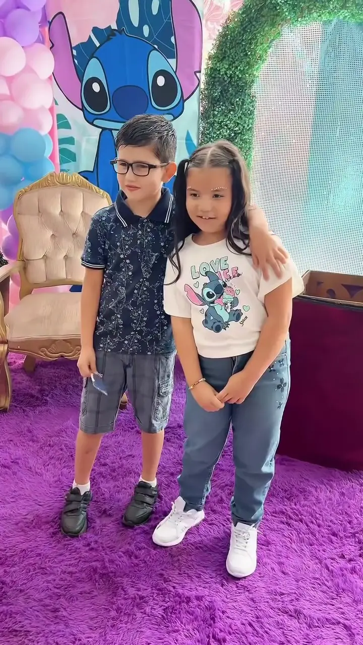 Hermanos posando en un cumpleaños de colores